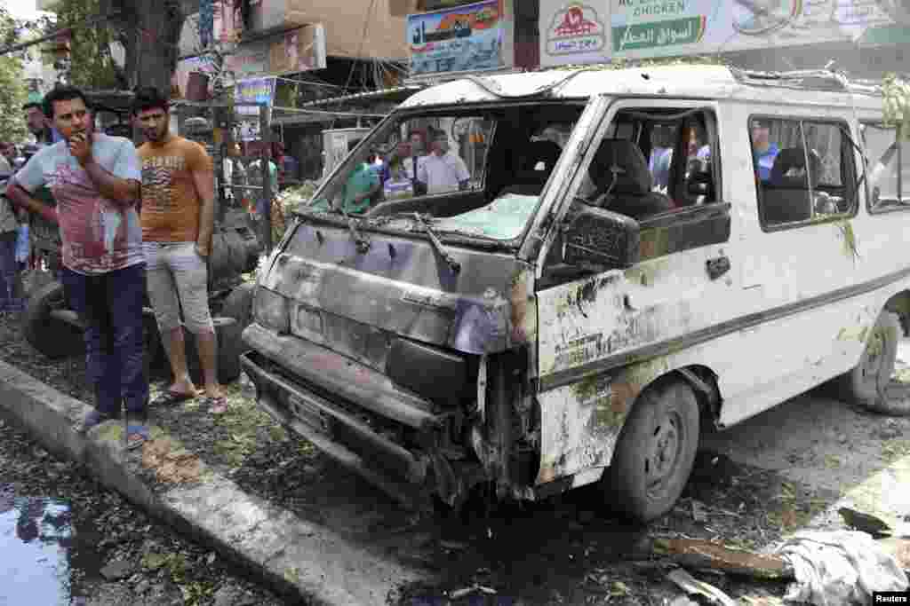 Residents gather at the site of a car bomb attack in Baghdad, May 30, 2013. 