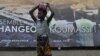 A girl stands next to a campaign poster of Cisse Ibrahima "Bacongo," a candidate for the municipal elections, on April 19, 2013 in Abidjan, two days ahead of the vote.