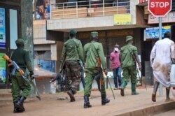FILE - Ugandan police and other security forces chase people off the streets to avoid unrest, as part of measures to prevent the potential spread of coronavirus disease, in Kampala, March 26, 2020.