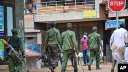 Ugandan police and other security forces chase people off the streets to avoid unrest, as part of measures to prevent the potential spread of coronavirus disease, in Kampala, Uganda, March 26, 2020. 