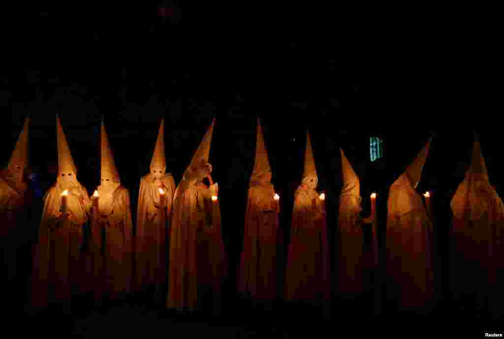 Penitents of La Paz (The Peace) brotherhood take part in a procession during Holy Week in the Andalusian capital of Seville, Spain, April 14, 2019.