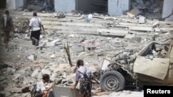 Soldiers are pictured through a window as they inspect the scene of a car bomb attack at a military police building in Mukalla city of the southern Yemeni province of Hadhramout. May 11, 2014.