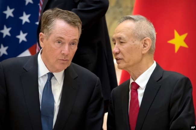Chinese Vice Premier Liu He, right, talks with U.S. Trade Representative Robert Lighthizer, while they line up for a group photo in Beijing, Feb. 15, 2019.