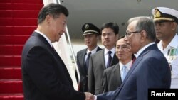 전날 캄보디아를 방문한 시진핑(왼쪽) 중국 국가주석이 14일 방글라데시 수도 다카에 도착한 직후 영접나온 압둘 하미드 대통령과 악수하고 있다.
