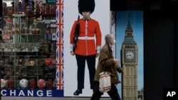 Seseorang yang memakai masker wajah berjalan melewati toko suvenir yang ditutup sementara di Oxford Street, selama penguncian virus korona kedua Inggris, di London, Senin, 23 November 2020. (Foto: AP)