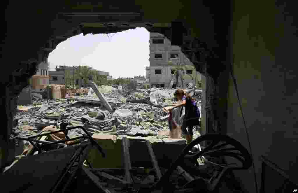 A member of the Abed Aal family salvages belongings from the family's house that was destroyed in an overnight Israeli strike in Gaza City, Aug. 2, 2014.