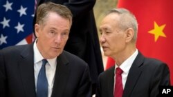 FILE - Chinese Vice Premier Liu He, right, talks with U.S. Trade Representative Robert Lighthizer, while they line up for a group photo in Beijing, Feb. 15, 2019.. 