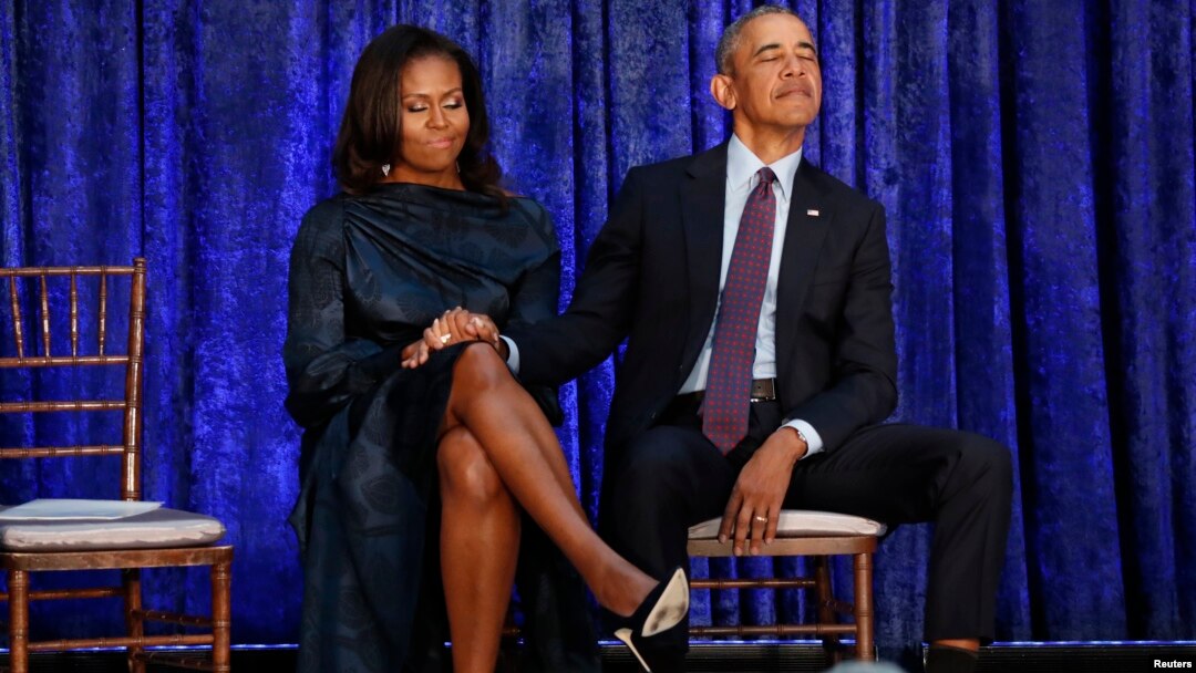 El presidente Barack Obama sostiene la mano de su esposa, Michelle, antes de desvelar sus retratos en la Galería Nacional de Retratos en Washington, el 12 de febrero.
