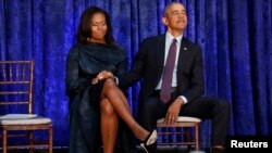 El presidente Barack Obama sostiene la mano de su esposa, Michelle, antes de desvelar sus retratos en la Galería Nacional de Retratos en Washington, el 12 de febrero.