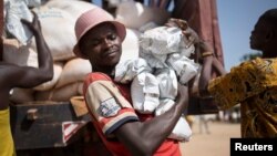 FILE - A man carries packages of food aid delivered by the U.N. Office for the Coordination of Humanitarian Affairs and World Food Program in Makunzi Wali, Central African Republic, April 27, 2017.