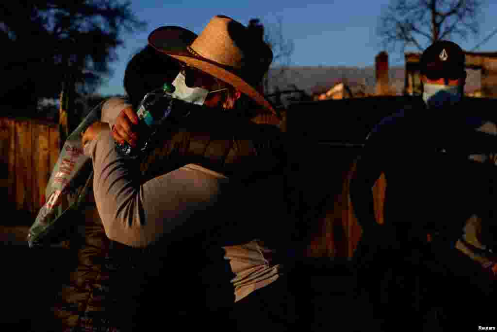 Ivette Torres is embraced by a neighbour as she stands outside her home of 20 years that was devastated by the Eaton fire, one of six simultaneous blazes that have ripped across Los Angeles County, in Altadena, California, Jan. 11, 2025. 