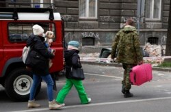 Pripadnik hrvatske vojske pomaže sugrađanki i njenoj porodici nakon snažnog zemljotresa u Zagrebu, Hrvatska, 22. marta 2020. (AP Photo/Darko Bandic)