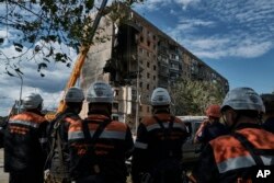 امدادگران اوکراینی در تلاش برای نجات بازماندگان حمله به ساختمان مسکونی ٩ طبقه در شهر کریوی‌ریه. دوشنبه ٣١ ژوئیه ۲۰۲۳