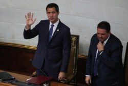 Venezuelan opposition leader Juan Guaido waves next to Stalin Gonzalez, second Vice President of the National Assembly, as they attend a session of the National Assembly in Caracas, Sept. 24, 2019.
