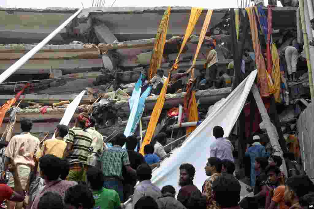 Rescue workers use clothes to bring down survivors and bodies after an eight-story building collapsed in Savar, Bangladesh, April 24, 2013.