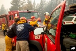 Firefighters plan their operations while battling the Camp Fire in Paradise, Calif., Nov. 10, 2018.