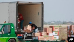 Workers unload a cargo plane carrying medical aid at the Baghdad Airport in Iraq, Monday, April 20, 2020.