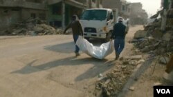 موصل میں امدادی کارکن ایک لاش کو پلاسٹک کے تھیلے میں ڈال کر لے جا رہے ہیں۔