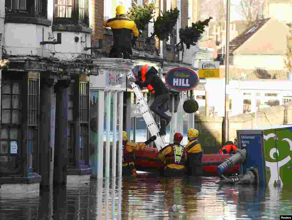 Members of the emergency services rescue a group of people from a flooded street in Tadcaster, northern England.