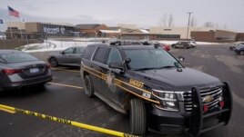 An Oakland County Sheriff's deputy guards the parking lot of Oxford High School in Oxford, Mich., Wednesday, Dec. 1, 2021. A 15-year-old sophomore opened fire at the school, killing several students and wounding multiple other people, including a teacher.
