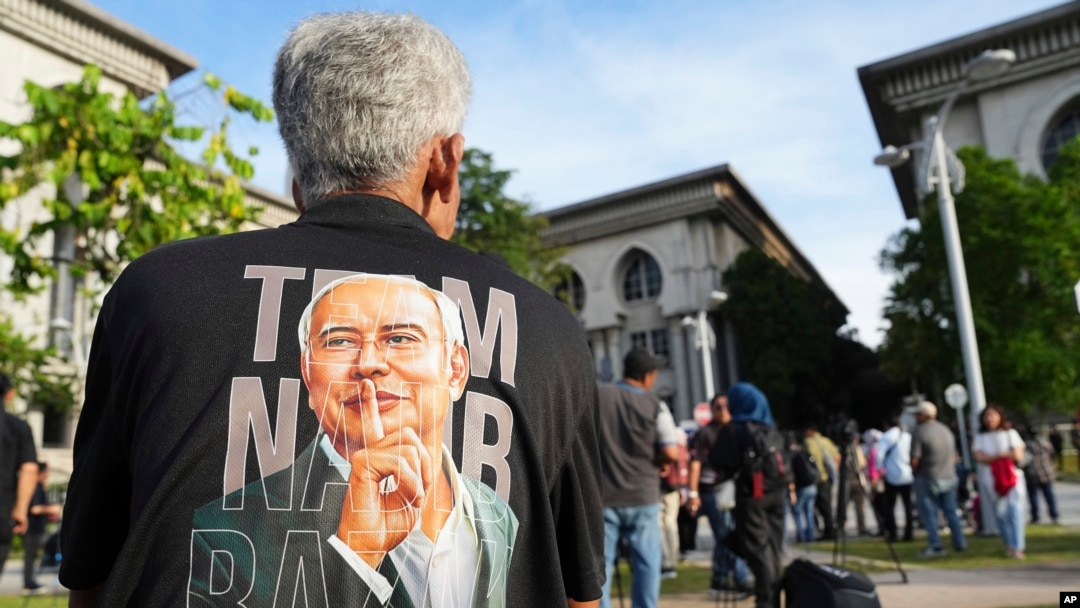 A supporter of former Prime Minister Najib Razak waits outside the Court of Appeals, in Putrajaya, Malaysia, Jan. 6, 2025, before Najib won an appeal to pursue his bid to serve his remaining corruption sentence under house arrest later Monday. 