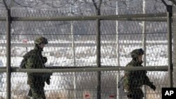 دوو سه‌ربازی کۆریای باشور پاسه‌وانی له‌ ناوچه‌یه‌کی سـنووری نێوان وڵاته‌که‌یان و کۆریای باکور ده‌که‌ن، 1 ی یه‌کی 2011