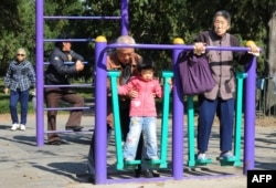資料照：北京天壇公園裡的老年人和他們的獨生子女的孫輩在鍛煉身體。 （2011年10月25日）