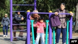 北京天壇公園裡的老年人和他們的獨生子女的孫輩在鍛煉身體。（2011年10月25日）