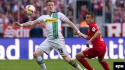 L’attaquant Rafinha de Munich, à droite, et André Hahn de Gladbach se battent pour récupérer un ballon lors du match de football de la Bundesliga entre le Bayern Munich et le Borussia Moenchengladbach au stade Allian, à Munich, Allemagne, 30 avril 2016.