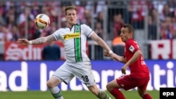 L’attaquant Rafinha de Munich, à droite, et André Hahn de Gladbach se battent pour récupérer un ballon lors du match de la Bundesliga entre le Bayern Munich et le Borussia Moenchengladbach au stade Allian, à Munich, Allemagne, 30 avril 2016.