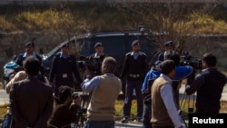 A car carrying former Pakistani President Pervez Musharraf, drives past members of the media as he leaves the special court formed to try him for treason in Islamabad Feb. 18, 2014.