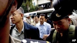 Thai activists Veera Somkwamkid, second left, a core leader of Yellow Shirts and Panich Vikitsreth, a member of Parliment of the ruling Democrat party, second right, are escorted by Cambodian court security personnel at Phnom Penh Municipal Court.