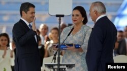 Honduran President Juan Orlando Hernandez, accompanied by his wife, Ana Garcia de Hernandez, and President of the National Congress of Honduras Mauricio Oliva, is sworn in for a new term at the Tiburcio Carias Andino National Stadium in Tegucigalpa, Honduras, Jan. 27, 2018.