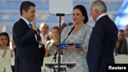 Le président hondurien Juan Orlando Hernandez prête serment, en présence de son épouse, Ana Garcia, et du président du Congrès National du Honduras, Mauricio Oliva, à Tegucigalpa, le 27 janvier 2018. (REUTERS/Jorge Cabrera)