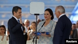 Presiden Honduras Juan Orlando Hernandez, didampingi istrinya, Ana Garcia de Hernandez, dan Presiden Kongres Nasional Honduras Mauricio Oliva, dilantik untuk masa jabatan baru di Stadion Nasional Tiburcio Carias, di Tegucigalpa, Honduras, 27 Januari 2018.