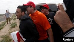 Pro-Trump rally participants yell at an anti-Trump protester as the two sides clash during the Southern California Make America Great Again march in support of President Trump, the military and first responders at Bolsa Chica State Beach in Huntington Beach, California, March 25, 2017.