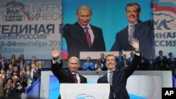 Russian President Dmitry Medvedev, right, and Prime Minister Vladimir Putin wave during a United Russia party congress in Moscow, September 24, 2011.