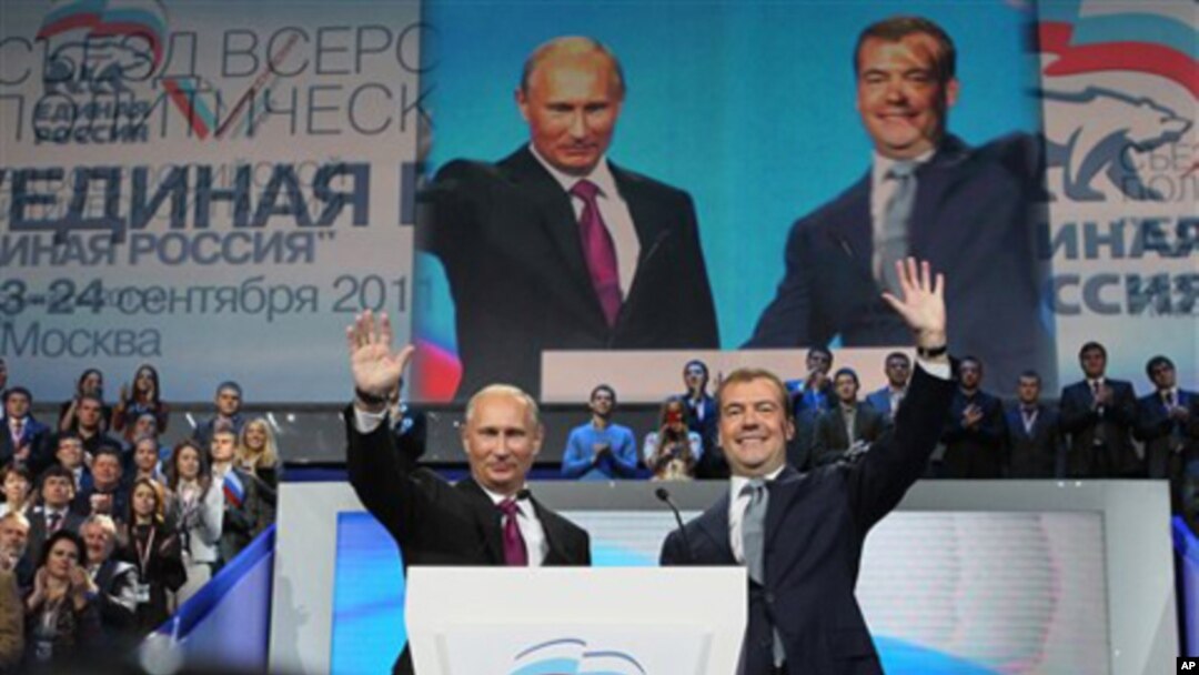 Russian President Dmitry Medvedev, right, and Prime Minister Vladimir Putin wave during a United Russia party congress in Moscow, September 24, 2011.