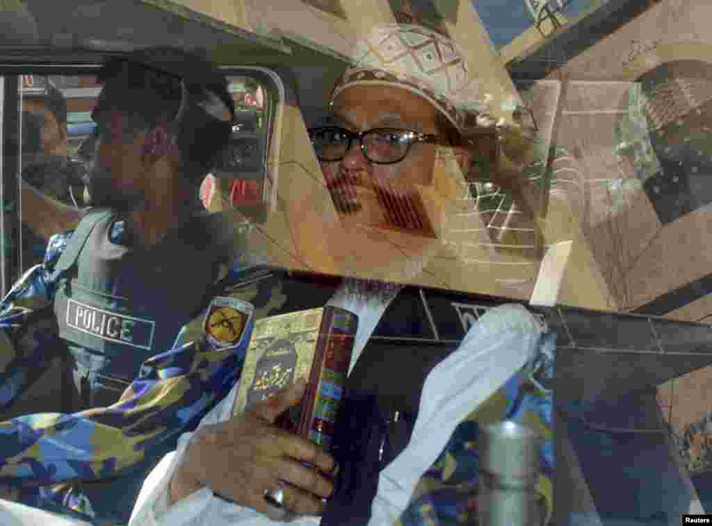 Delwar Hossain Sayedee (R), 73, vice-president of the Jamaat-e-Islami party, sits inside a vehicle next to a police officer on his way to a court in Dhaka February 28, 2013. A Bangladesh tribunal sentenced an Islamist party leader to death on Thursday, th