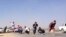 Protesters hide during an attack on a Libyan militia, the Libya Shield brigade, headquarters in Benghazi, June 8, 2013. 