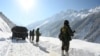 FILE - Indian army soldiers walk along a road near Zojila mountain pass that connects Srinagar to the union territory of Ladakh, bordering China on February 28, 2021.