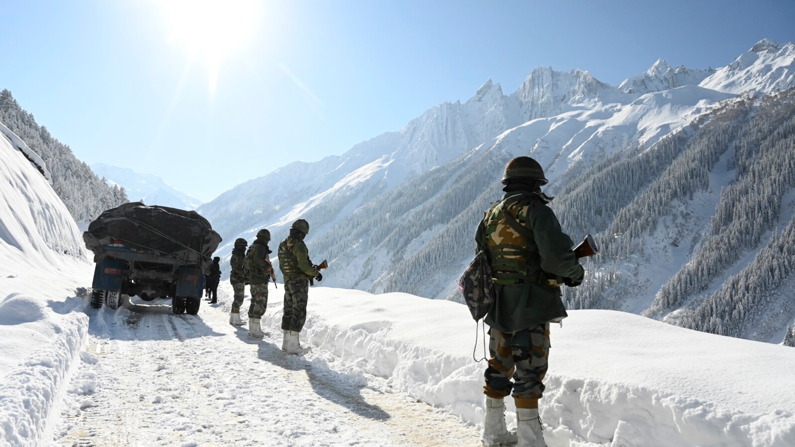 FILE - Indian army soldiers walk along a road near Zojila mountain pass that connects Srinagar to the union territory of Ladakh, bordering China on February 28, 2021.