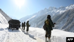 FILE - Indian army soldiers walk along a road near Zojila mountain pass that connects Srinagar to the union territory of Ladakh, bordering China on February 28, 2021.