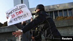 Police officers restrain a protester during a rally of journalists against a new media bill, in front of the Parliament building in Baku, Azerbaijan, on Dec. 28, 2021. 