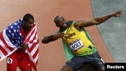 Pelari Jamaika, Ussain Bolt (kanan) dan pelari AS yang berada di urutan ketiga, Justin Gatlin, merayakan kemenangan dalam final lari 100 meter putra Olimpiade London 2012 (5/8). Bolt akan kembali berlaga dalam nomor lari 200 meter, hari ini (7/8).