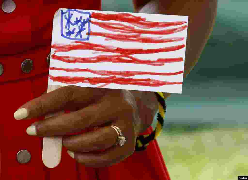 First lady Michelle Obama holds a U.S. flag made by a child during a visit to the U.S. Army Garrison at Vicenza, northern Italy.