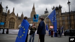 FILE - Anti-Brexit and remain in the European Union supporters stand near Houses of Parliament in London, April 3, 2019. 