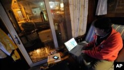 David C. Bond of Wickford, R.I. checks weather forecasts on his computer while riding out Sandy on his boat docked in Annapolis, Md. Monday, Oct. 29, 2012. Sandy continued on its path Monday, as the storm forced the shutdown of mass transit, schools and f