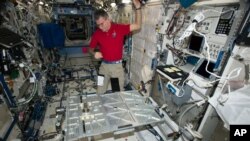 In this photo provided the European Space Agency on Wednesday, Oct. 25, 2017, Italian astronaut Paolo Nespoli looks at the Multipurpose Transporting Plate aboard the International Space Station. Pope Francis is making his first phone call off the planet - and into space.