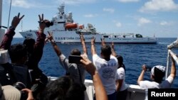 Sebuah kapal Penjaga Pantai China bermanuver untuk menghalangi kapal logistik pemerintah Filipina yang mengangkut awak media di kawasan Second Thomas Shoal yang menjadi sengketa yang merupakan bagian dari Spratly Islands, di Laut China Selatan pada gambar yang diambil tanggal 29 Maret 2014.